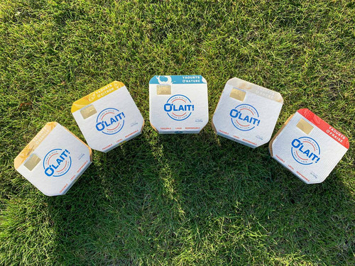 Dos pots de yaourts O'lait, en arc de cercle dans l'herbe Dos pots de yaourts O'lait, en arc de cercle dans l'herbe