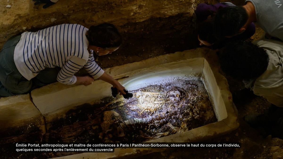 Émilie Portat, anthropologue et maître de conférences à Paris I Panthéon-Sorbonne, observe le haut du corps de l'individu, quelques secondes après l'enlèvement du couvercle